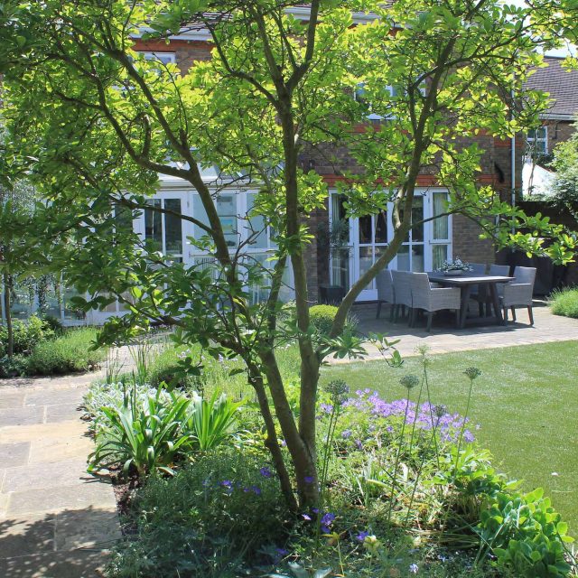 Wimbledon luxury artificial lawn, designed with York stone paving and reclaimed London stock bricks terraces hard landscaping external LED lighting London.