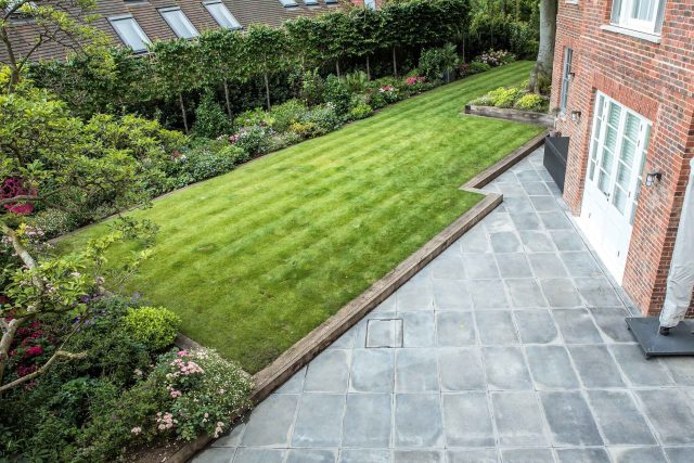 Garden design with traditional style railings and gate to match the characteristics of the Hampstead area in which the house sits, thoughtful lower planting.