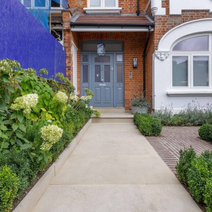 Family garden design in Barnes West London, lawn space as possible for various play activities and an intimate dining area with pleached Quercus Ilex trees.