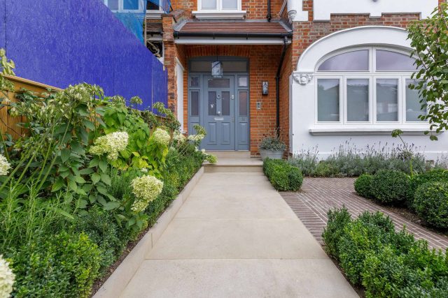Family garden design in Barnes West London, lawn space as possible for various play activities and an intimate dining area with pleached Quercus Ilex trees.