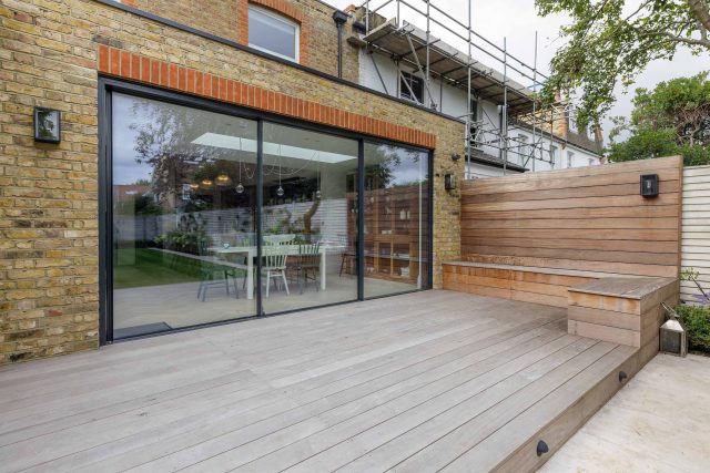 Family garden design in Barnes West London, lawn space as possible for various play activities and an intimate dining area with pleached Quercus Ilex trees.