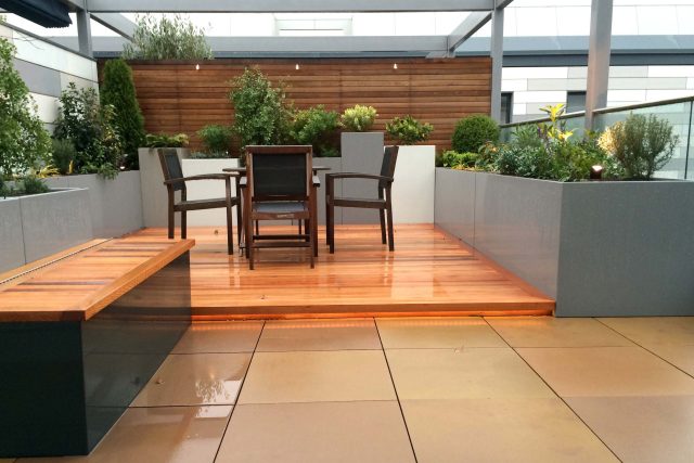 Kings Cross Roof Terrace at new apartments, Pippa Martlew, Cedar timber, aluminium planters, looks fantastic at night challenging build specialist company.