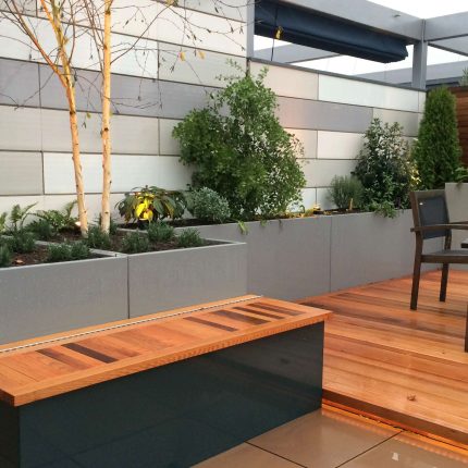 Kings Cross Roof Terrace at new apartments, Pippa Martlew, Cedar timber, aluminium planters, looks fantastic at night challenging build specialist company.