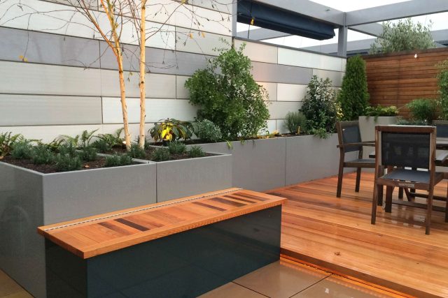 Kings Cross Roof Terrace at new apartments, Pippa Martlew, Cedar timber, aluminium planters, looks fantastic at night challenging build specialist company.