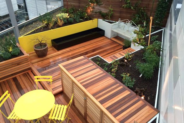 Kings Cross Roof Terrace at new apartments, Pippa Martlew, Cedar timber, aluminium planters, looks fantastic at night challenging build specialist company.