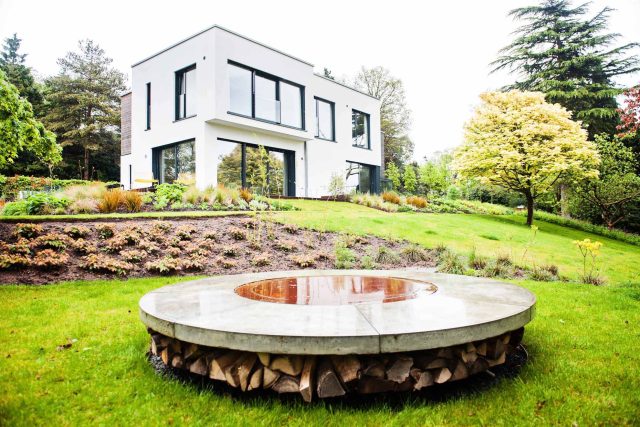 Farnham Garden Design Purbeck stone with multi-level Ipe hardwood decking, lawns and wild flower meadow and sculptural fire table Surrey landscaping.