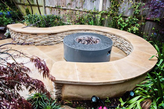 Family Garden with summer house in West London Feltham, curved seating bench, Charcoal Norstone tiered walling, specialist garden contractors horticulturists.