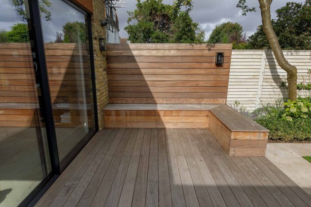 Family garden design in Barnes West London, lawn space as possible for various play activities and an intimate dining area with pleached Quercus Ilex trees.