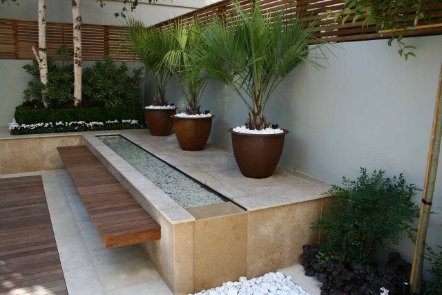 Contemporary outdoor garden space designed by Kate Gould and built by the Garden Builders, water feature, floating bench, cedar bench, landscaping contractors.