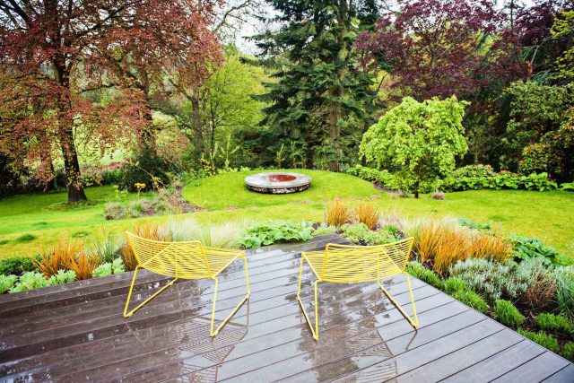 Farnham Garden Design Purbeck stone with multi-level Ipe hardwood decking, lawns and wild flower meadow and sculptural fire table Surrey landscaping.