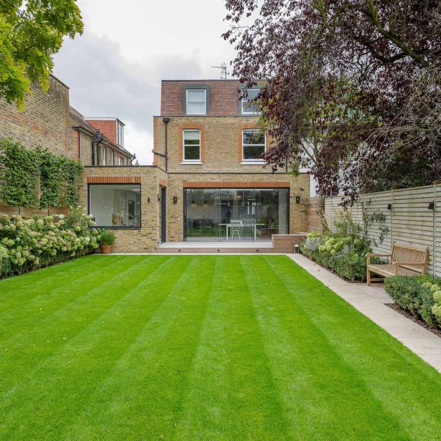 Family garden design in Barnes West London, lawn space as possible for various play activities and an intimate dining area with pleached Quercus Ilex trees.