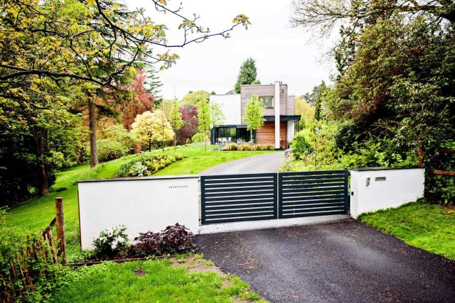 Farnham Garden Design Purbeck stone with multi-level Ipe hardwood decking, lawns and wild flower meadow and sculptural fire table Surrey landscaping.