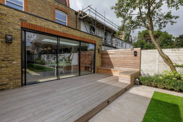Family garden design in Barnes West London, lawn space as possible for various play activities and an intimate dining area with pleached Quercus Ilex trees.