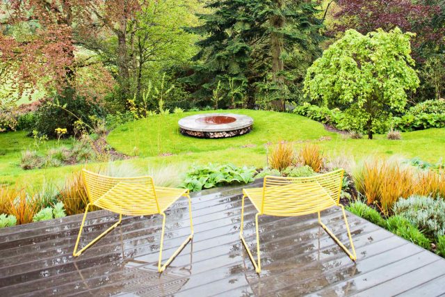 Farnham Garden Design Purbeck stone with multi-level Ipe hardwood decking, lawns and wild flower meadow and sculptural fire table Surrey landscaping.